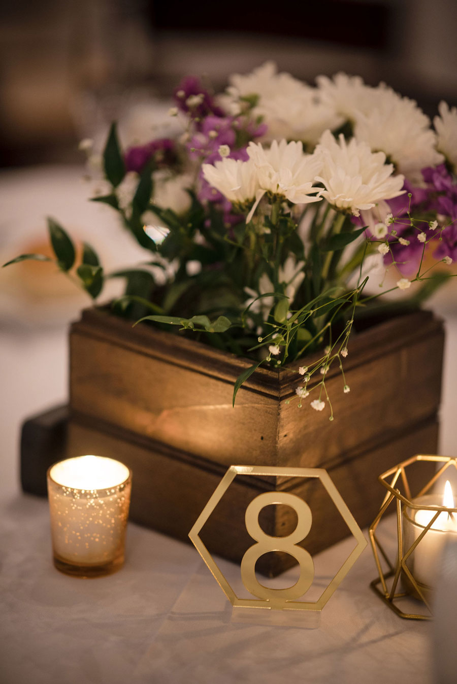 Brushed metal table numbers with floral arrangements