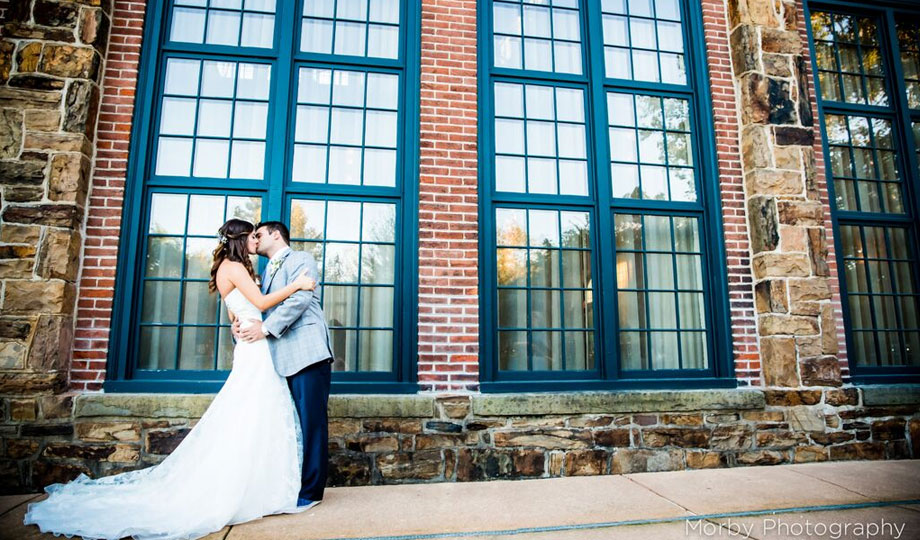 Bride and groom kissing outside the Poenixville Foundry